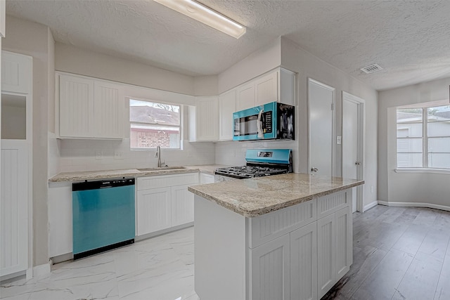 kitchen featuring sink, white cabinets, stainless steel appliances, and a textured ceiling