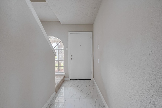 doorway to outside featuring a textured ceiling