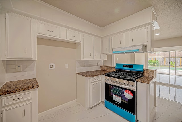 kitchen featuring ventilation hood, dark stone countertops, tasteful backsplash, white cabinetry, and range with gas cooktop