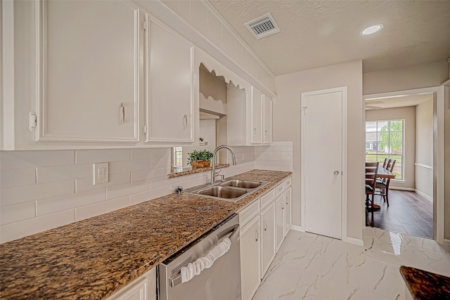 kitchen with white cabinetry, dishwasher, sink, backsplash, and a textured ceiling