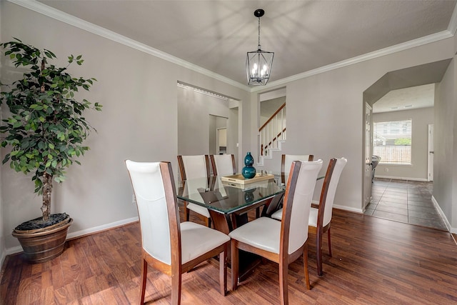 dining space featuring dark hardwood / wood-style floors, crown molding, and a chandelier