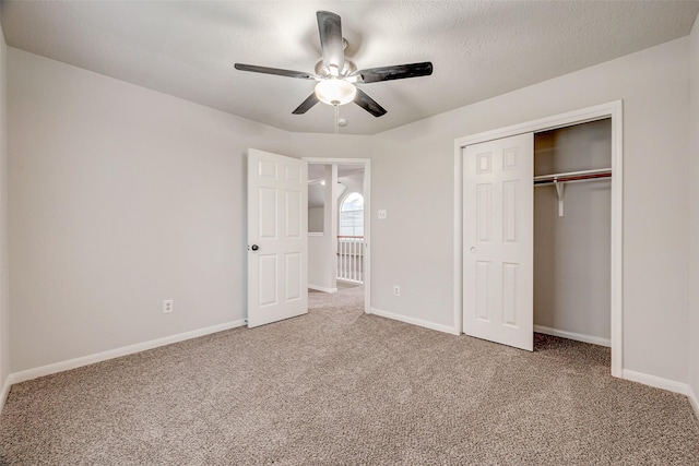 unfurnished bedroom featuring ceiling fan, a closet, carpet, and a textured ceiling