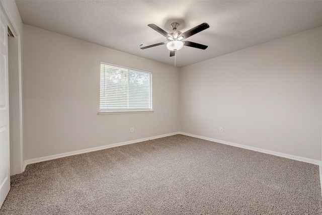 carpeted spare room featuring ceiling fan and a textured ceiling