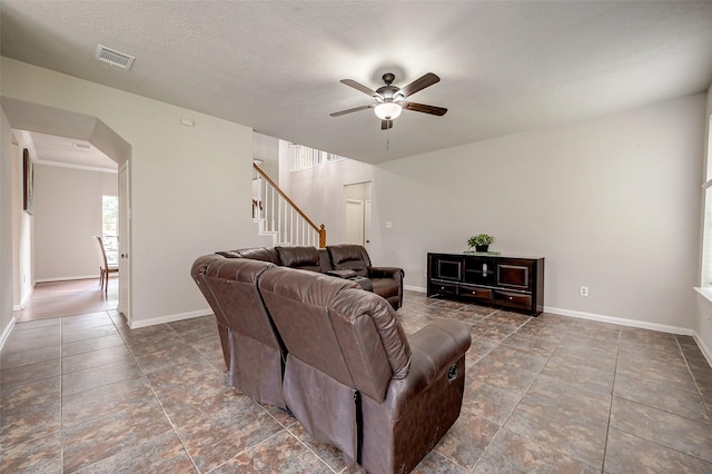 living room featuring ceiling fan and a textured ceiling