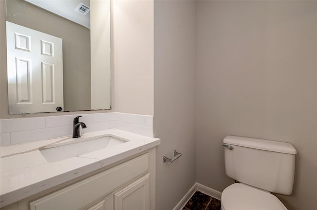 bathroom featuring tasteful backsplash, vanity, and toilet