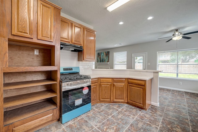 kitchen with decorative backsplash, kitchen peninsula, stainless steel gas range, a textured ceiling, and ceiling fan