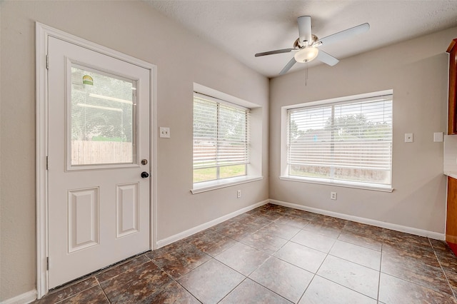 tiled foyer with ceiling fan and a textured ceiling