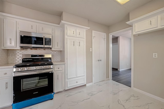 kitchen featuring appliances with stainless steel finishes, tasteful backsplash, and white cabinetry