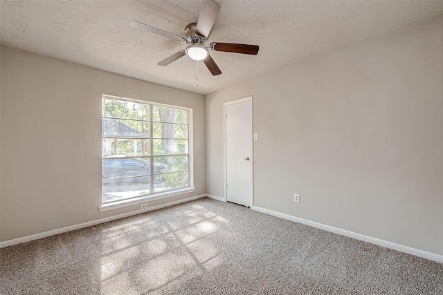 carpeted spare room featuring a textured ceiling and ceiling fan