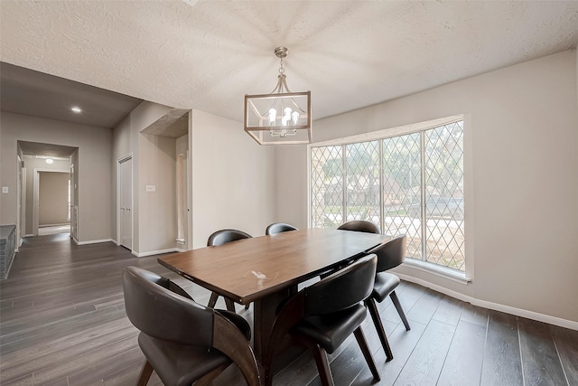 dining area with a chandelier, a textured ceiling, and dark hardwood / wood-style floors