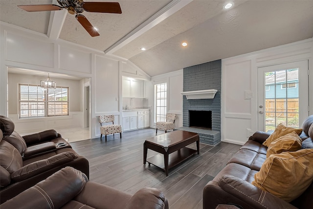 living room featuring ceiling fan, hardwood / wood-style floors, lofted ceiling with beams, and plenty of natural light