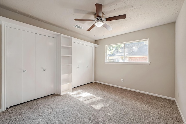 unfurnished bedroom with a textured ceiling, carpet floors, and ceiling fan