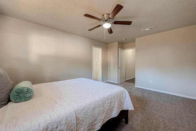 carpeted bedroom with ceiling fan and a textured ceiling