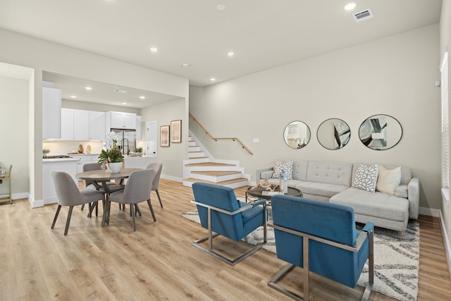 living room with sink and light hardwood / wood-style flooring