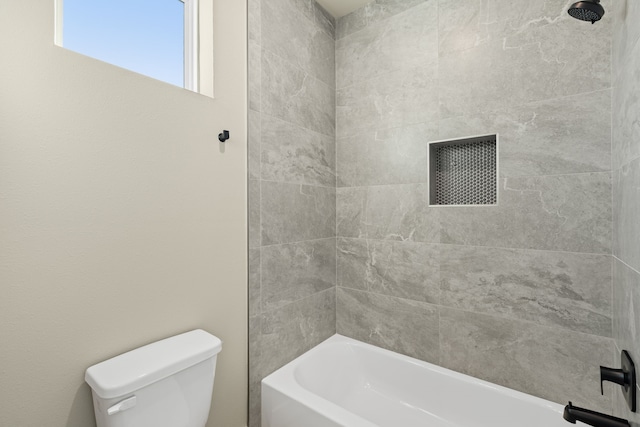 bathroom with tiled shower / bath and toilet