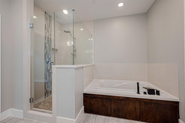 full bathroom featuring a shower stall, a bath, and recessed lighting