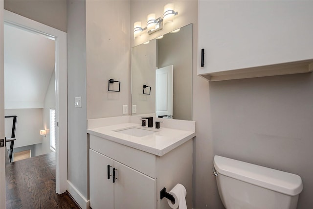 bathroom with toilet, wood finished floors, and vanity