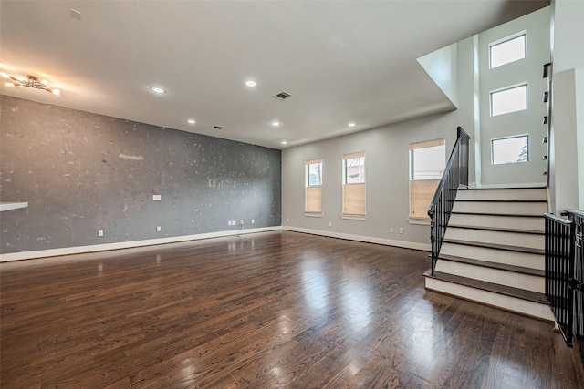 empty room featuring baseboards, visible vents, wood finished floors, stairs, and recessed lighting