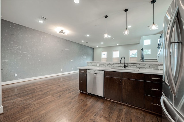 kitchen featuring sink, hanging light fixtures, dark wood-type flooring, dark brown cabinets, and appliances with stainless steel finishes