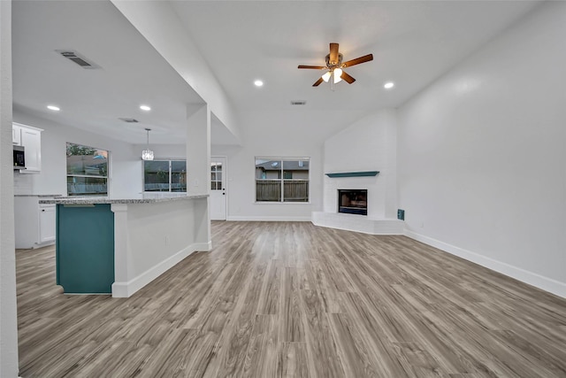 unfurnished living room with ceiling fan, light hardwood / wood-style floors, and a brick fireplace