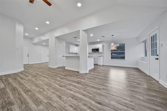 unfurnished living room featuring ceiling fan and light hardwood / wood-style floors