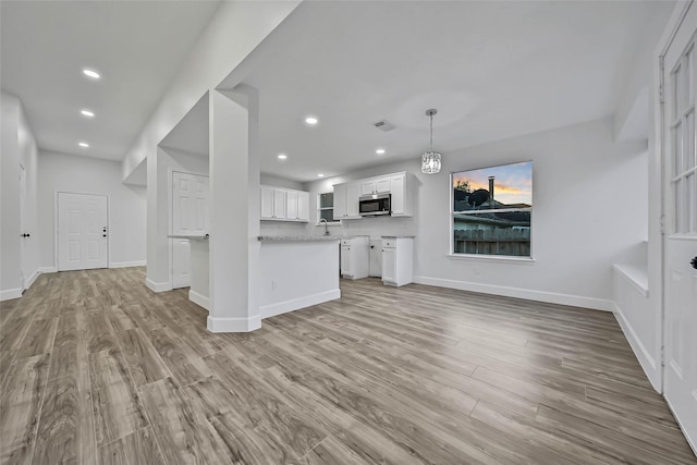 unfurnished living room with light hardwood / wood-style floors and sink