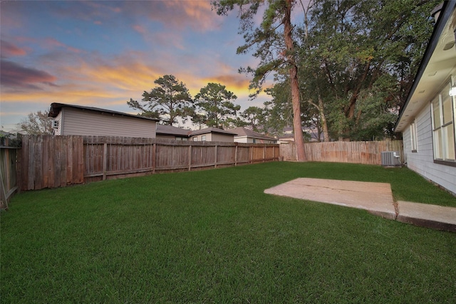 yard at dusk with central AC unit