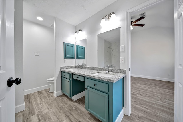 bathroom featuring wood-type flooring, vanity, toilet, and ceiling fan