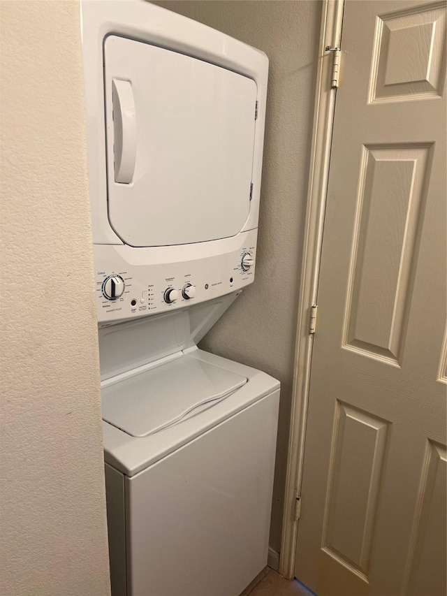 laundry room featuring stacked washer / drying machine