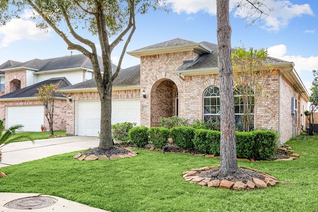 view of front of home with a garage and a front lawn