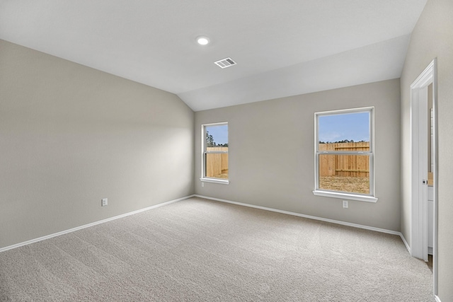 carpeted empty room with lofted ceiling and a healthy amount of sunlight