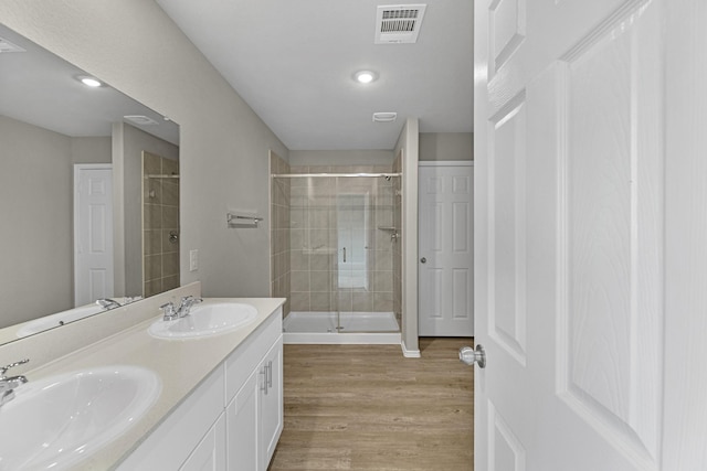 bathroom with vanity, wood-type flooring, and walk in shower