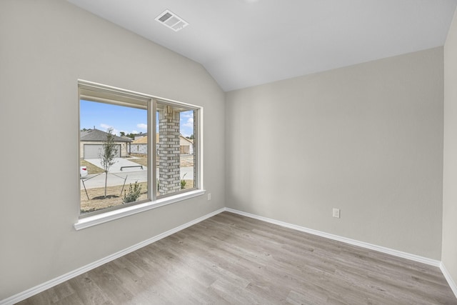 unfurnished room with lofted ceiling and light hardwood / wood-style flooring