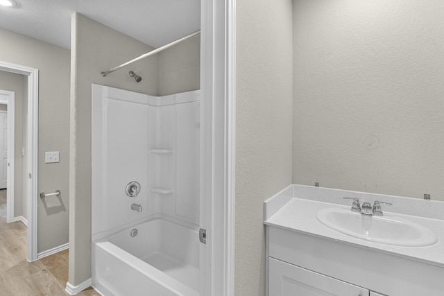 bathroom featuring hardwood / wood-style floors, vanity, and shower / bathtub combination