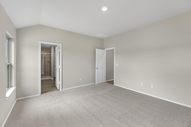 carpeted empty room featuring vaulted ceiling and a healthy amount of sunlight