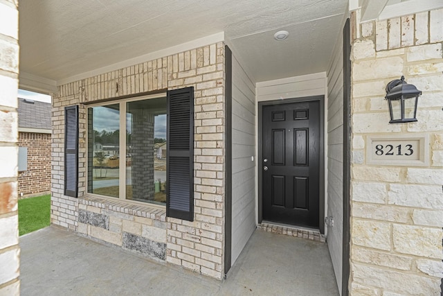 view of exterior entry featuring covered porch