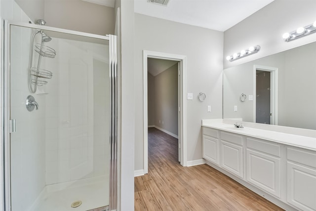 bathroom featuring an enclosed shower, vanity, and hardwood / wood-style floors