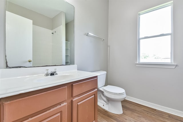 bathroom featuring walk in shower, hardwood / wood-style floors, vanity, and toilet