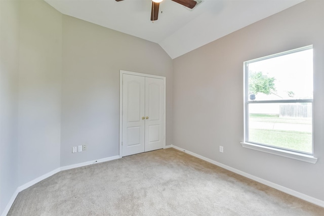 carpeted empty room with ceiling fan and vaulted ceiling