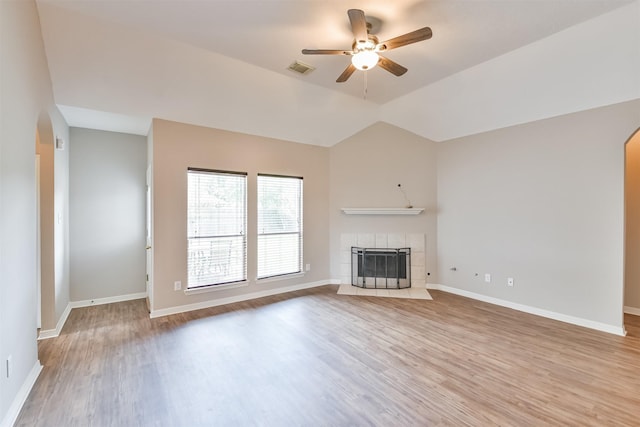 unfurnished living room featuring a tiled fireplace, ceiling fan, light hardwood / wood-style floors, and lofted ceiling