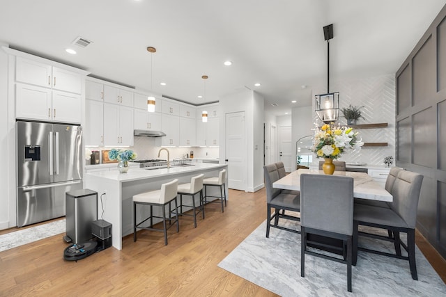 dining area with light hardwood / wood-style floors and sink