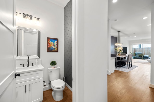 bathroom with toilet, vanity, and hardwood / wood-style flooring