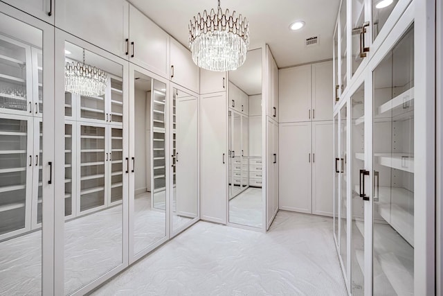 walk in closet featuring a notable chandelier