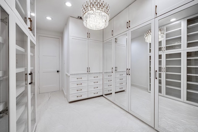 walk in closet with a chandelier