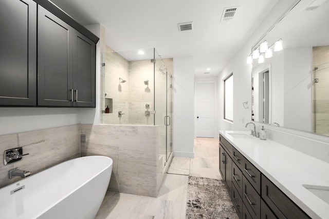 bathroom with vanity, separate shower and tub, and tile walls