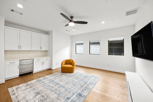 living area with light wood-type flooring and ceiling fan