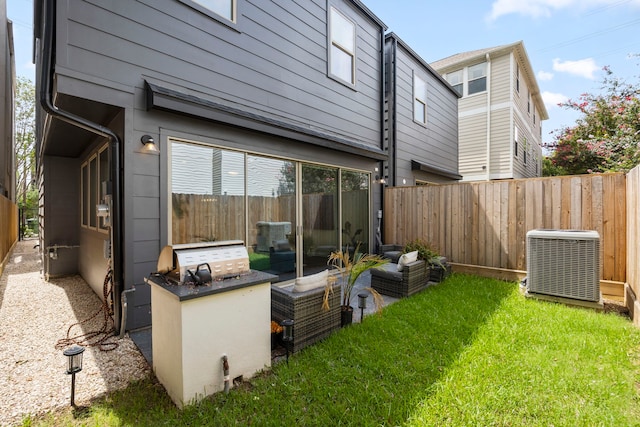 rear view of property featuring a yard, cooling unit, and an outdoor hangout area