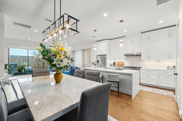 dining space featuring sink and light wood-type flooring