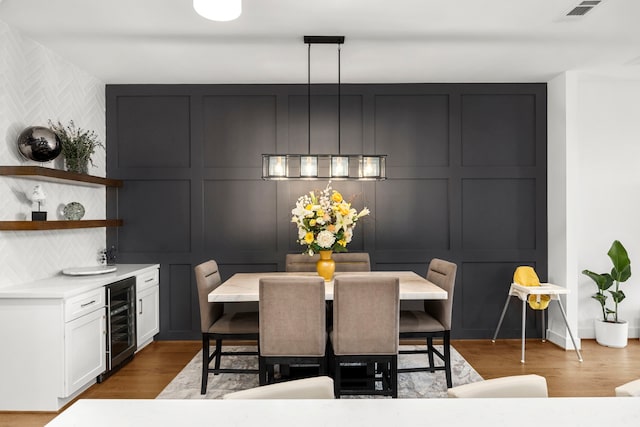 dining space featuring light hardwood / wood-style floors and wine cooler