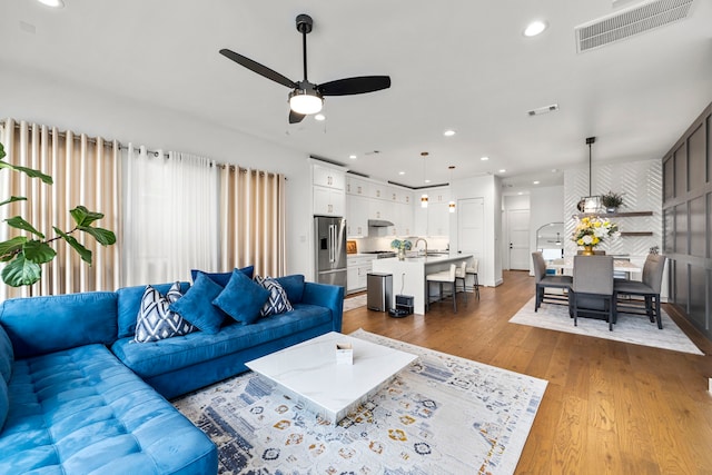 living room with ceiling fan, dark wood-type flooring, and sink